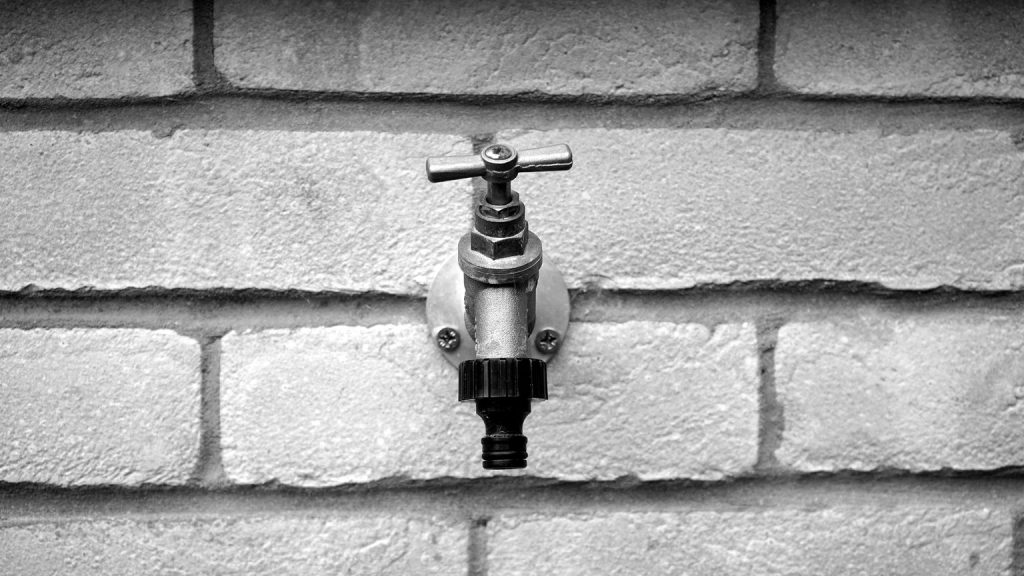 Robinet de puisage extérieur fixé sur un mur en brique