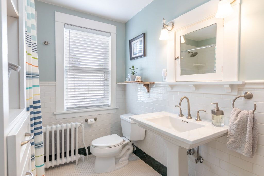 Salle de bain classique avec lavabo en colonne blanc, mitigeur chromé et radiateur