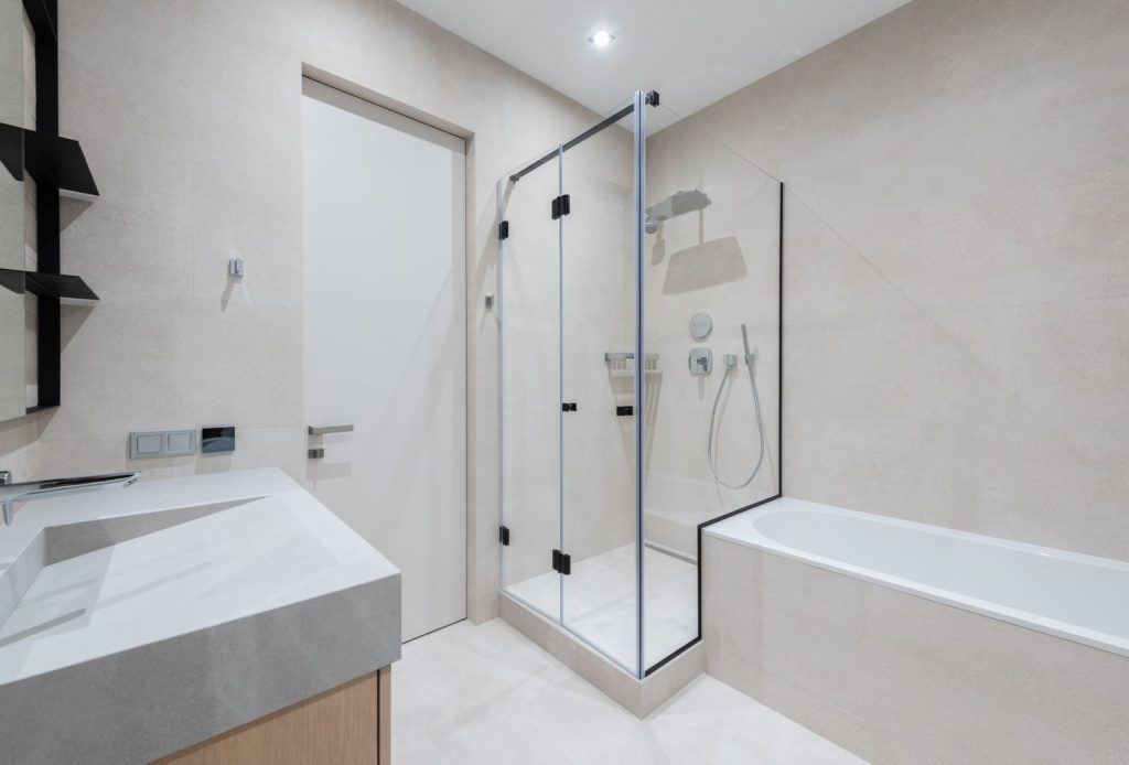 Paroi de douche vitrée avec joints noirs sur les bords et charnières