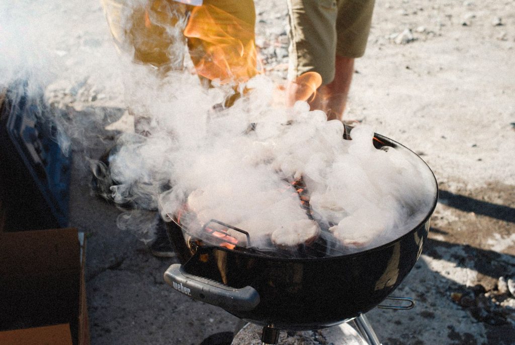Barbecue au charbon de bois à couvercle dégageant de la fumée