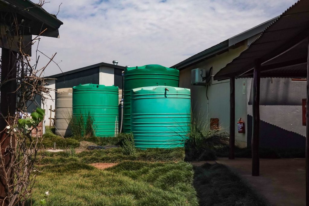Cuves de récupération d'eau de pluie installées près d'un bâtiment