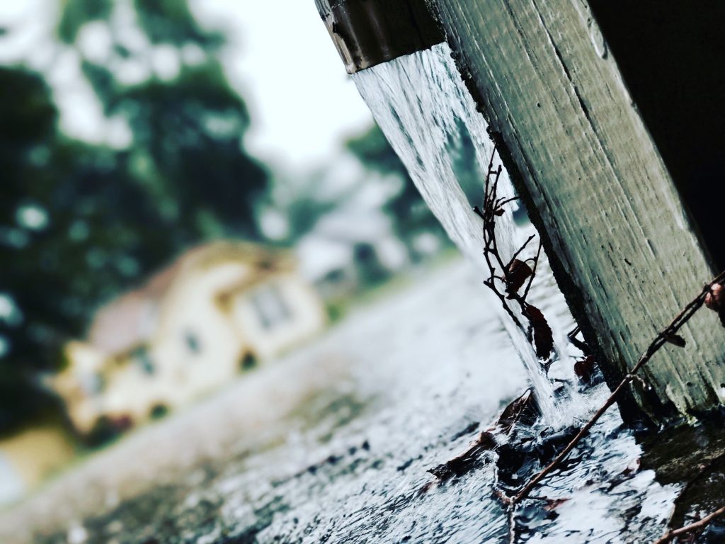 Eau de pluie s'écoulant d'une gouttière pendant une averse