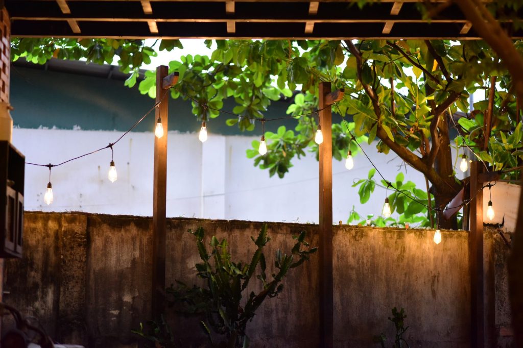 Guirlande lumineuse d'extérieur suspendue sous une pergola au-dessus d'une terrasse