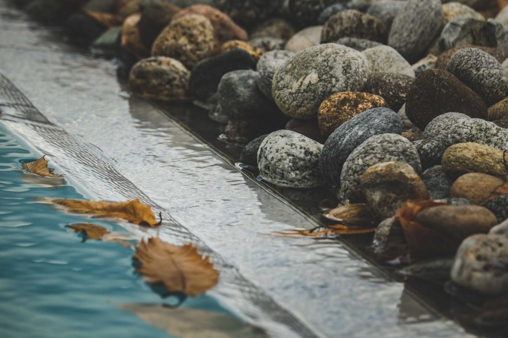 Feuilles d'automne flottant au bord d'une piscine avant l'hivernage