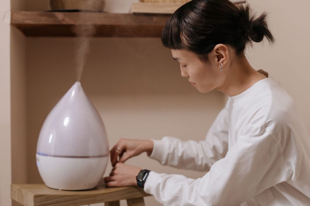 Personne réglant un humidificateur d'air dans une pièce