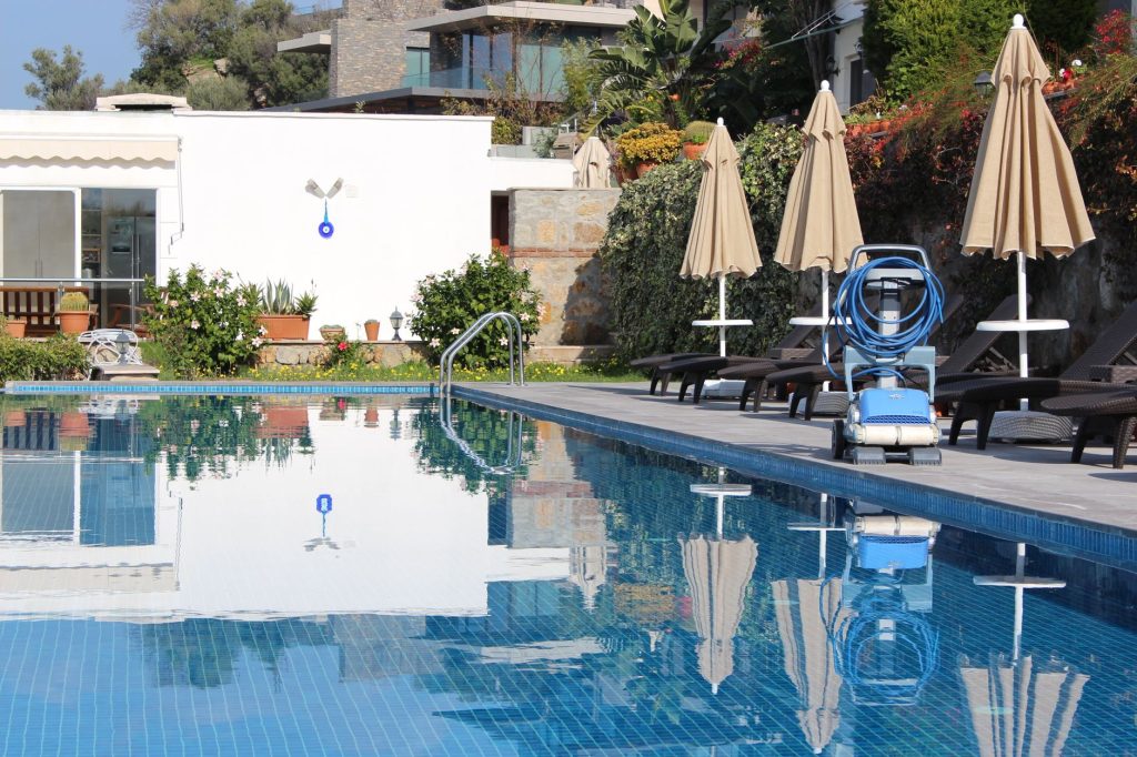 Robot de piscine posé sur son chariot de transport avec son câble enroulé au bord du bassin