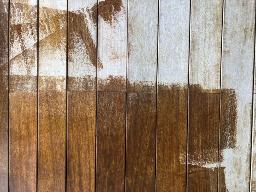 Planches de bois dont l'ancienne finition brune et blanche s'écaille par plaques